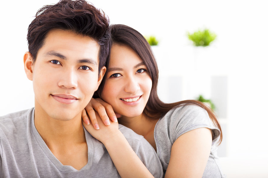Young happy asian couple hugging and smiling