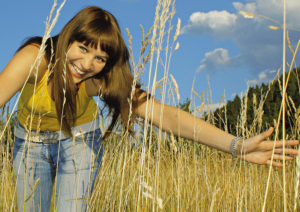 girl in high grass on a sunny day.