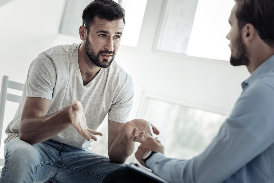 Man talking with another man in gender-specific treatment for substance abuse.