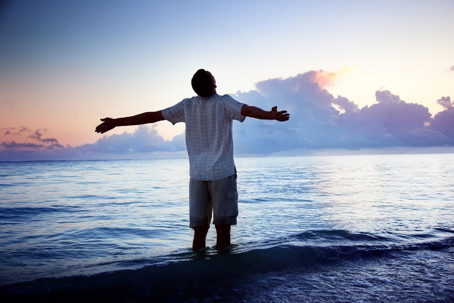Man standing by the ocean restoring his relationship with God.