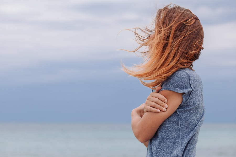 Woman standing by the ocean thinking about opioid effects on the brain.