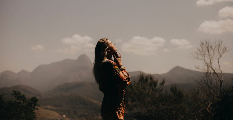 A woman, symbolizing the struggle of Klonopin addiction, finds solace amidst a breathtaking mountain landscape, emphasizing the journey to recovery.
