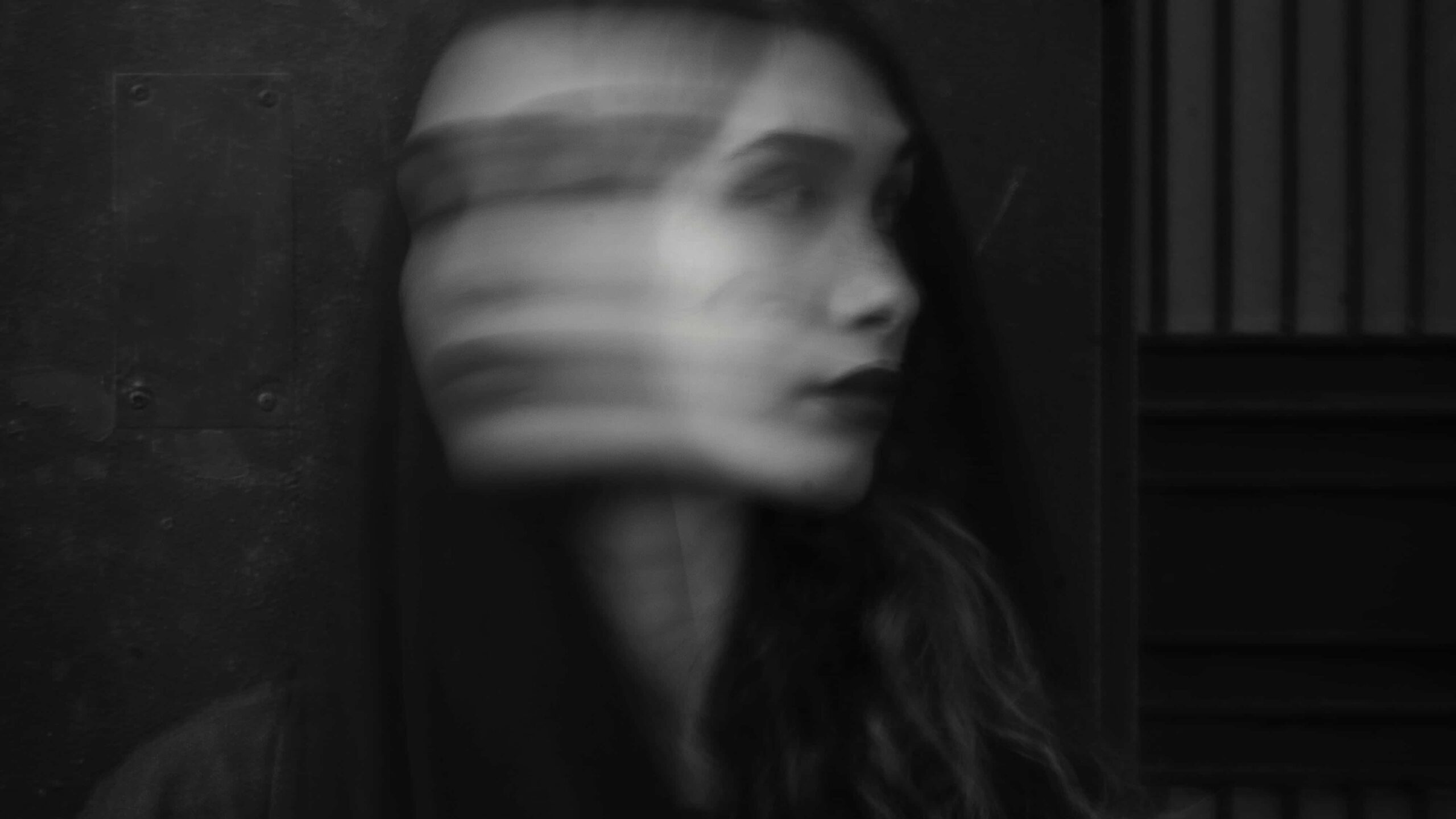 Artistic portrait of a woman with a blurred face split into two directions representing the conflicting emotions experienced in physical and psychological drug dependence.