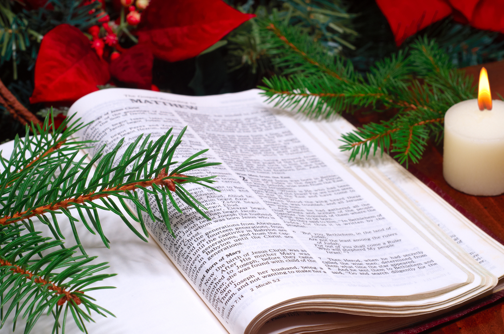 Open Bible surrounded by Christmas ornaments