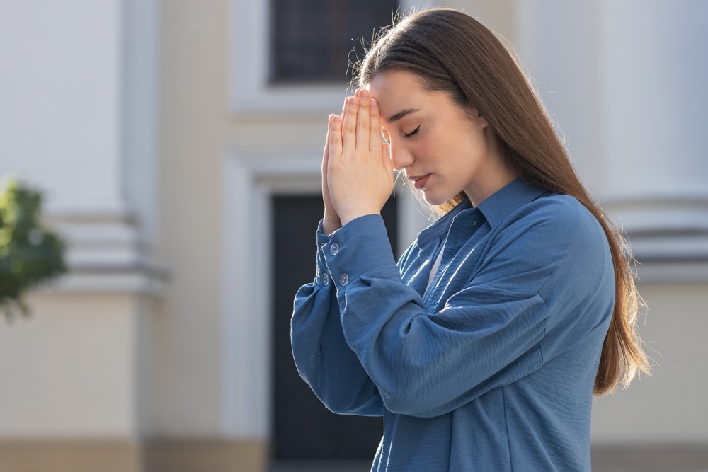 Female praying for her loved ones struggling with substance abuse 