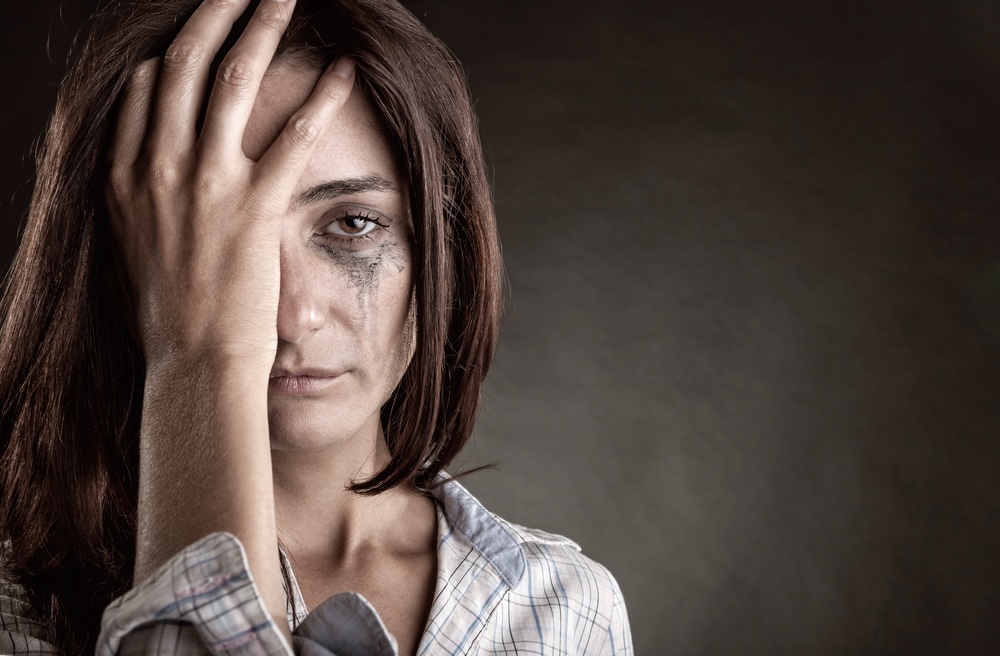 Woman dealing with addiction issues with tears and smudges on her face