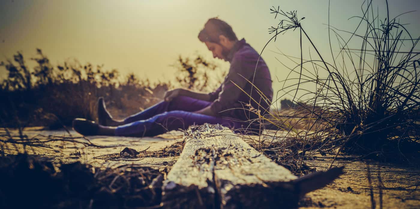 Man sitting on train tracks thinking about bad decisions and if he might need to go to rehab in California