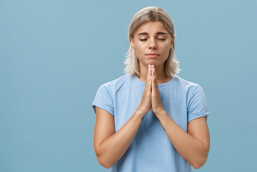 Female praying as she deals with her recovery from addiction in Christian rehab