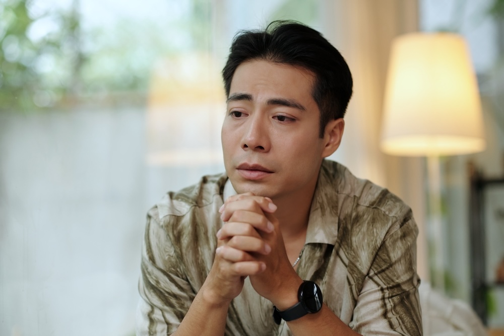 Man praying for sobriety while in recovery from drug addiction