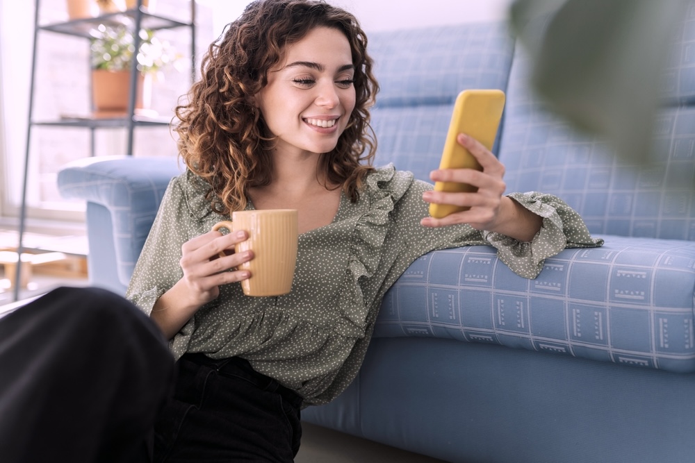 Woman sitting while looking on her phone